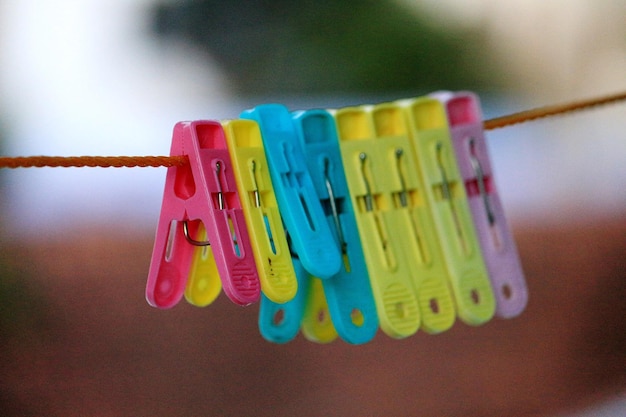 Zdjęcie zbliżenie kolorowych szpilek na pranie wiszących na sznurku do prania