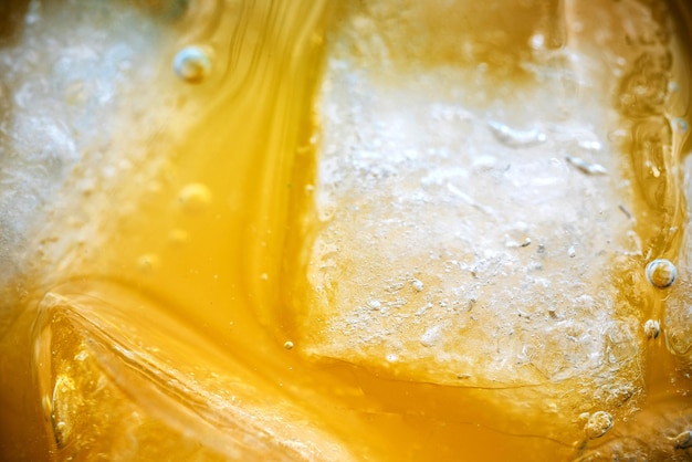 Zbliżenie kostek lodu w soku pomarańczowym