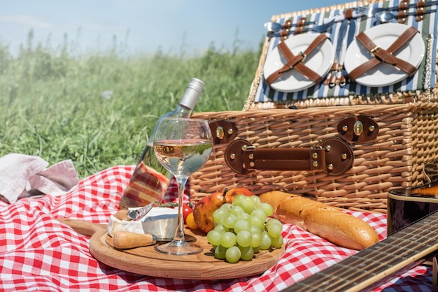 Zbliżenie kosz piknikowy z napojami i jedzeniem na trawie