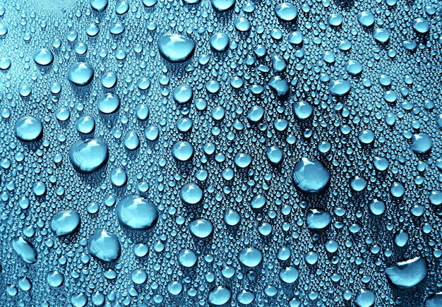 Zbliżenie kropli wody na niebieskiej powierzchni