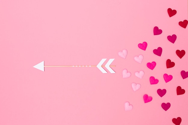 Zdjęcie zbliżenie kształtu serca z strzałką na różowym tle