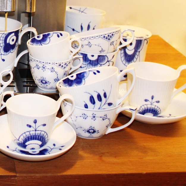 Zdjęcie zbliżenie kubków herbaty i talerzy na stole