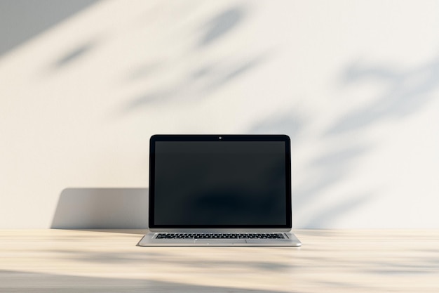 Zbliżenie laptopa z pustym ekranem i makieta miejsce w drewnianym miejscu pracy z cieniami Renderowanie 3D