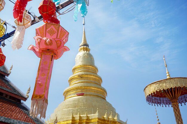 Zdjęcie zbliżenie latarnie w stylu thai lanna do powieszenia przed złotą pagodą w tajskiej świątyni