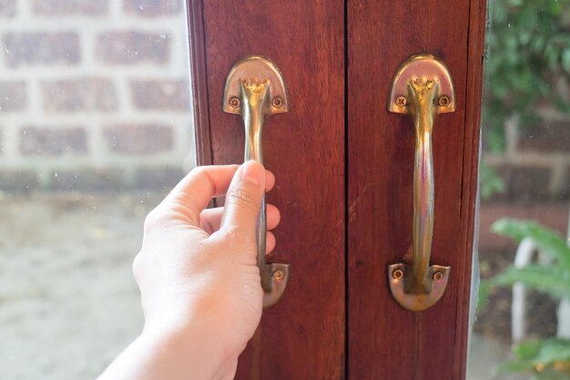 Zdjęcie zbliżenie ludzkiej ręki na metalowych drzwiach