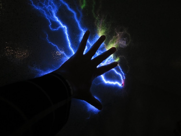 Zdjęcie zbliżenie ludzkiej ręki na oświetlonym świetle
