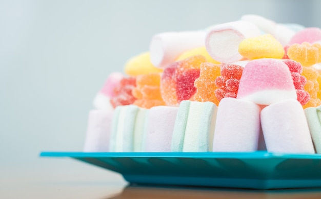 Zbliżenie Marshmallows I Galaretki Ciasto Na Niebieskim Talerzu Na Przyjęcie Dla Dzieci, W Delikatnych Pastelowych Odcieniach