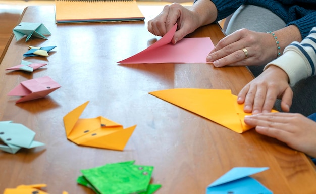 Zdjęcie zbliżenie matki z synem, gdy są w domu, robiąc rękodzieło origami