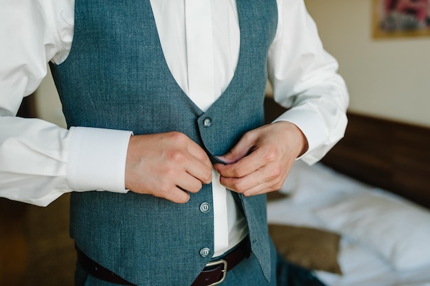 Zdjęcie zbliżenie męskie ręce zapinają guziki pan młody w garniturze koszula stylowa klasyczna odzież męska część biznesmen przygotowuje rano na dzień roboczy lub wesele