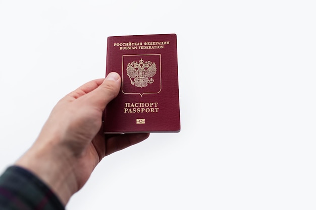 Zbliżenie męskiej ręki dając rosyjski paszport na białym tle
