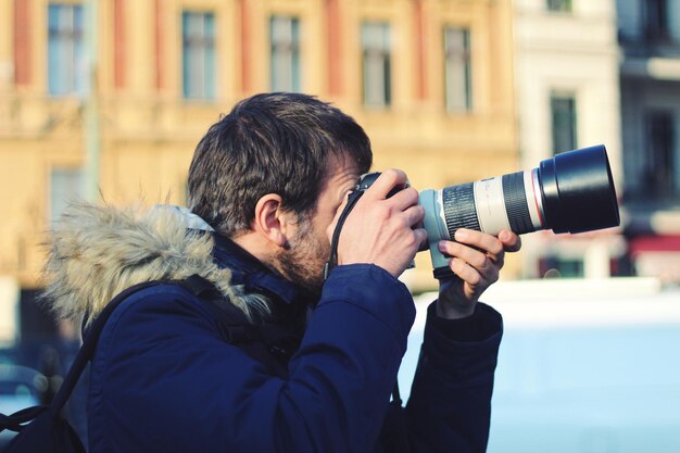 Zdjęcie zbliżenie mężczyzny fotografującego w mieście