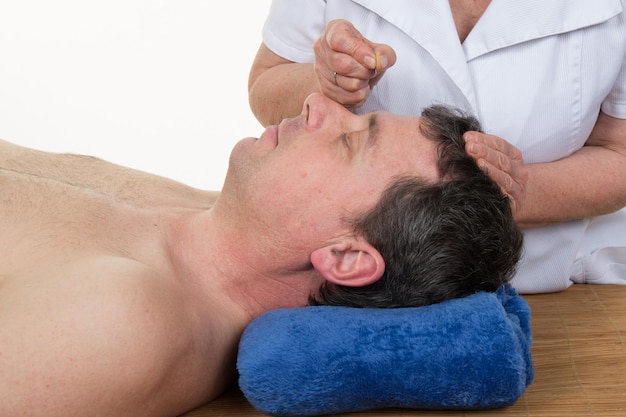 Zbliżenie mężczyzny poddawanego leczeniu akupunkturą