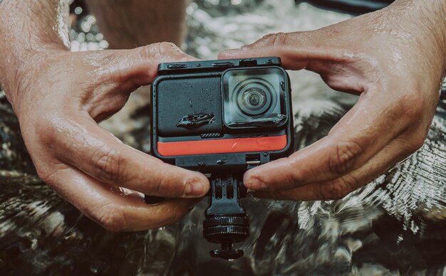 Zdjęcie zbliżenie mężczyzny trzymającego kamerę gopro