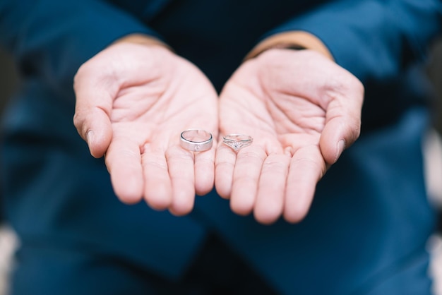 Zdjęcie zbliżenie mężczyzny trzymającego pierścienie ślubne