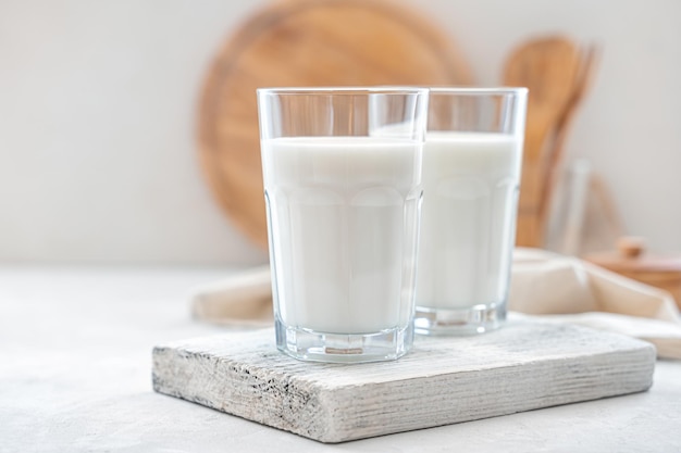 Zbliżenie mleka w dwóch szklankach na jasnym tle Widok z boku poziomy