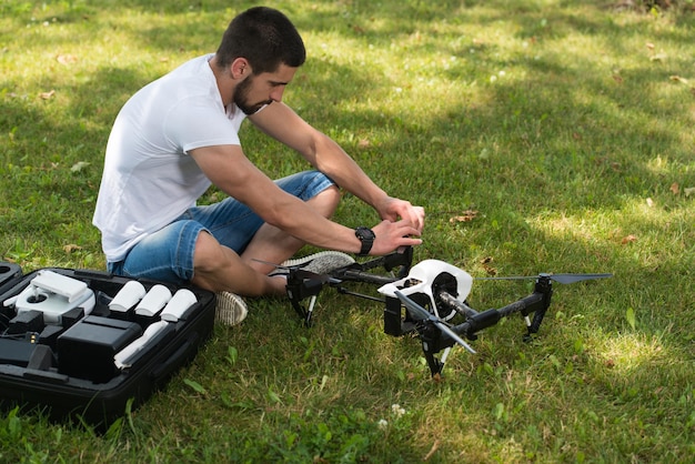 Zbliżenie młodego inżyniera dokręcającego śmigło drona Uav za pomocą narzędzia ręcznego w parku