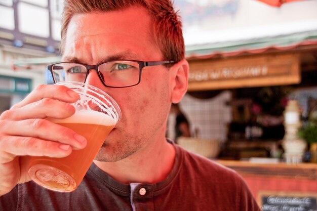 Zdjęcie zbliżenie młodego mężczyzny pijącego piwo na świeżym powietrzu