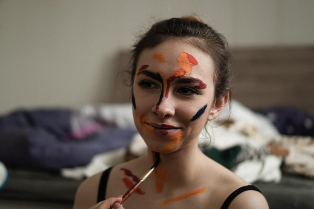Zdjęcie zbliżenie młodej kobiety nakładającej farbę na ciało