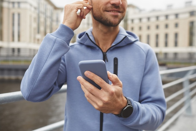 Zbliżenie: Młody Człowiek Przy Użyciu Swojego Telefonu Komórkowego Idąc Ulicą