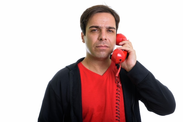 Zbliżenie młody mężczyzna perski rozmawia stary telefon na białym tle