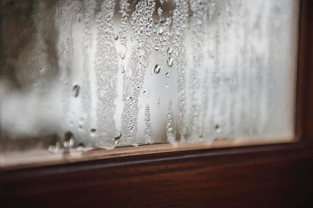 Zdjęcie zbliżenie mokrego okna szklanego w porze deszczowej