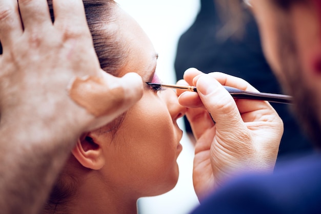 Zbliżenie na artystę makijaż człowieka coraz eyeliner do modelu.