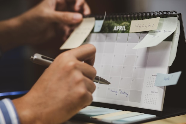 Zdjęcie zbliżenie na biznesmena sprawdzającego notatkę i planowanie harmonogramu w terminarzu kalendarza