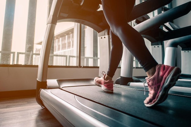 Zdjęcie zbliżenie na buty, kobiety biegające na siłowni na bieżni.ćwiczenie koncepcji.fitness i zdrowy styl życia