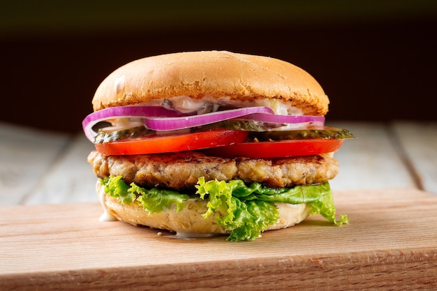 Zbliżenie na chickenburger z piklami na desce