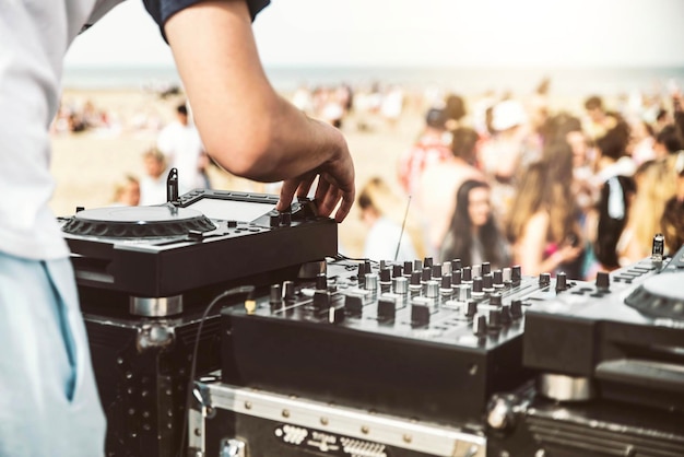 Zbliżenie na deejay grającego muzykę elektroniczną na letniej imprezie na plaży