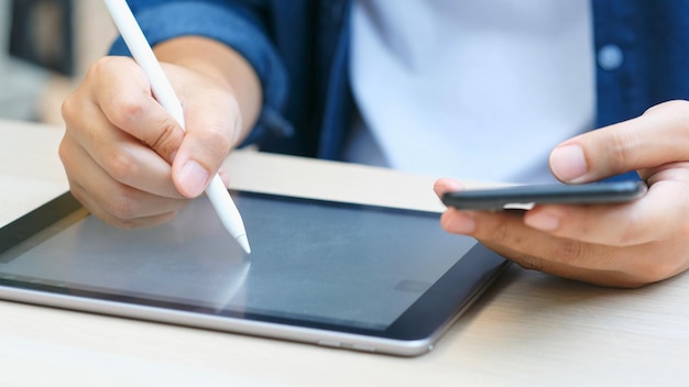 Zbliżenie na dłoni człowieka pisania na cyfrowym tablecie podczas pracy w domu studium online