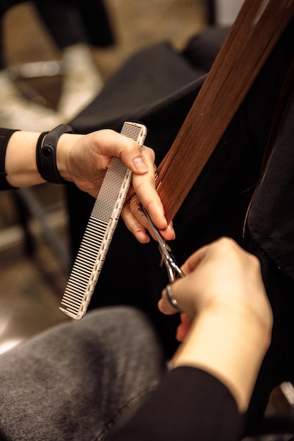 Zbliżenie na fryzjera strzyżenia włosów klientów w salonie kosmetycznym strzyżenia włosów nożyczkami