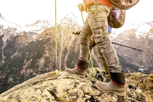 Zbliżenie na nogi trekkingowe i buty na francuskich alpach Turysta z plecakami i kijami