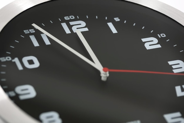 Zbliżenie na ogólny czarno-srebrny zegar ścienny pokazujący godzinę jedenastą