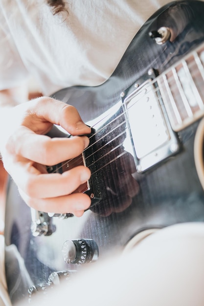 Zbliżenie na parę rąk grających na gitarze na zewnątrz. Słoneczny dzień i ćwiczenie koncepcji instrumentu. Skopiuj kosmiczne życie muzyczne na trasie i przyrodzie.