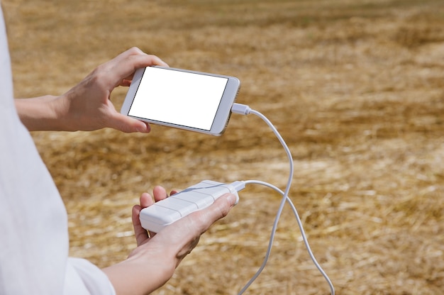 Zbliżenie na puste ładowanie telefonu z banku mocy trzymanego w rękach