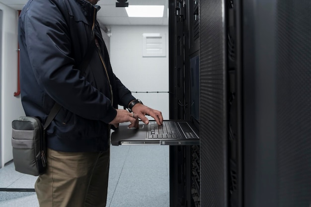 Zbliżenie na ręce inżyniera centrum danych Korzystanie z klawiatury na superkomputerze. Specjalista w zakresie serwerowni z męskim administratorem systemu współpracującym z siecią ochrony danych w celu zapewnienia cyberbezpieczeństwa.