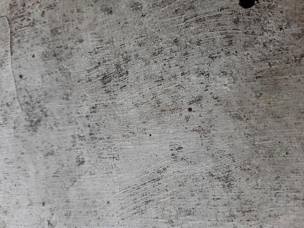 Zbliżenie na szarą betonową powierzchnię z czarnymi znakami.