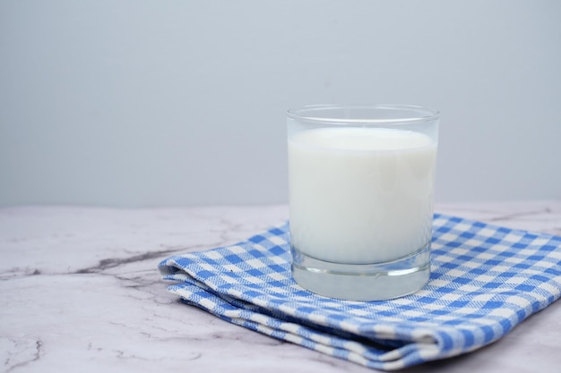 Zbliżenie na szklankę mleka i łyżkę na stole