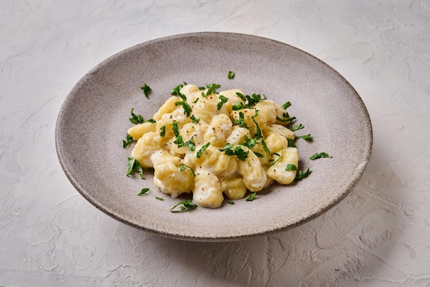 Zbliżenie na tradycyjne alpejskie danie gnocchi przygotowane z ziemniaków i ciasta z mąki pełnoziarnistej ze śmietaną