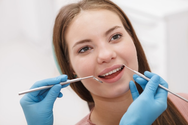 Zbliżenie na uśmiechniętą kobietę podczas badania stomatologicznego w klinice