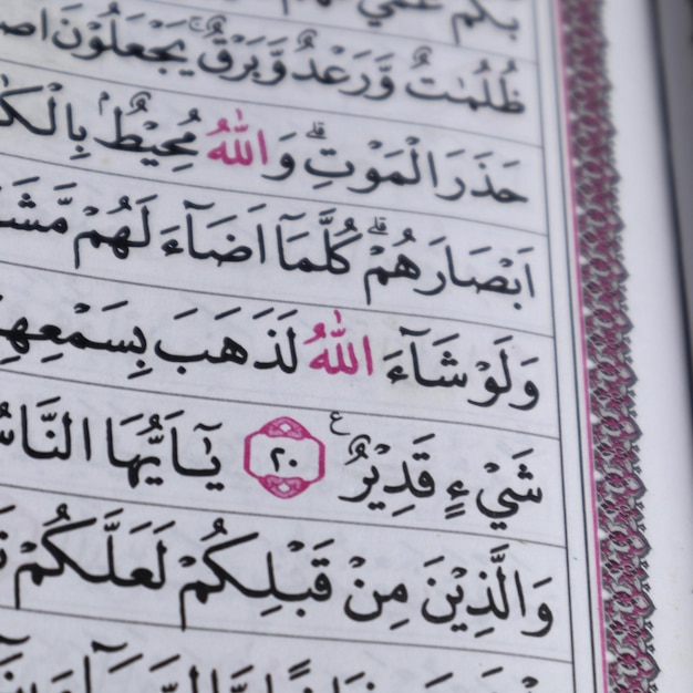 Zdjęcie zbliżenie na wersety koranu lub koranu. skup się na czerwonym tekście allaha lafadz