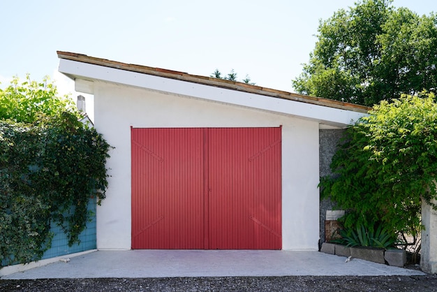 Zbliżenie na widok elewacji czerwonych klasycznych drewnianych drzwi garażowych