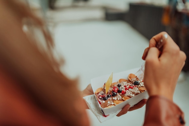 Zbliżenie na zdjęcie kobiety jedzącej świeże pyszne poffertjes Selective focus