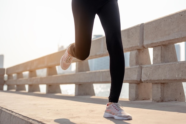 Zbliżenie: nogi młoda kobieta jogging w porannym treningu w mieście. Miasto, które zdrowo żyje w stolicy. Ćwiczenia, fitness, jogging, bieganie, styl życia, zdrowa koncepcja.