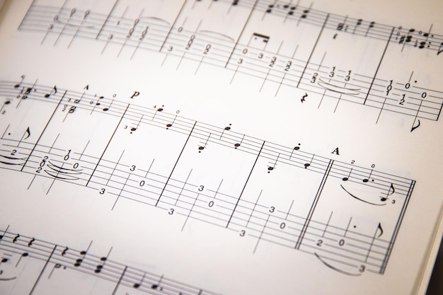 Zbliżenie nut muzycznych inskrypcji na białym papierze Wybraną ostrość