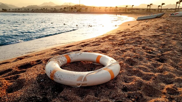 Zbliżenie Obraz Biały Plastikowy Pierścionek Ratujący życie Leżący Na Piaszczystej Plaży Przed Pięknym Zachodem Słońca Nad Wodą