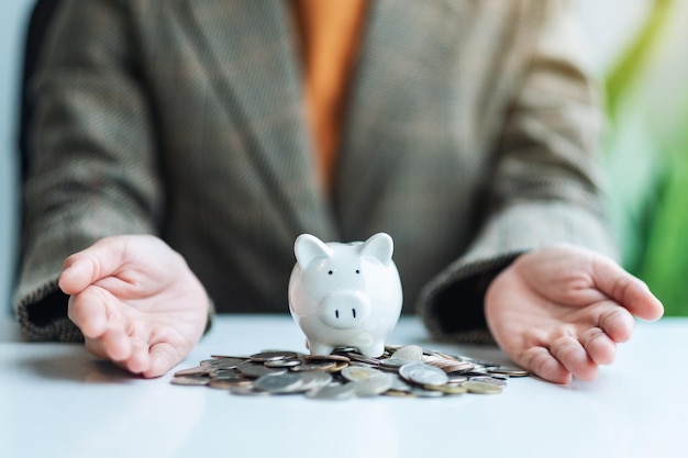 Zbliżenie obraz dłoni kobiety pokazujący skarbonkę i monety na stole dla koncepcji oszczędzania pieniędzy