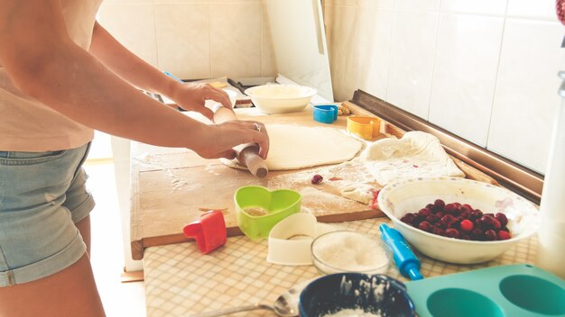 Zbliżenie Obraz Młodej Kobiety Toczenia Ciasta Z Drewnianym Wałkiem Do Ciasta. Gospodyni Robi Pizzę W Domu W Kuchni