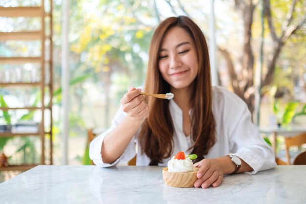 Zbliżenie obraz pięknej azjatyckiej kobiety lubi jeść lody w restauracji